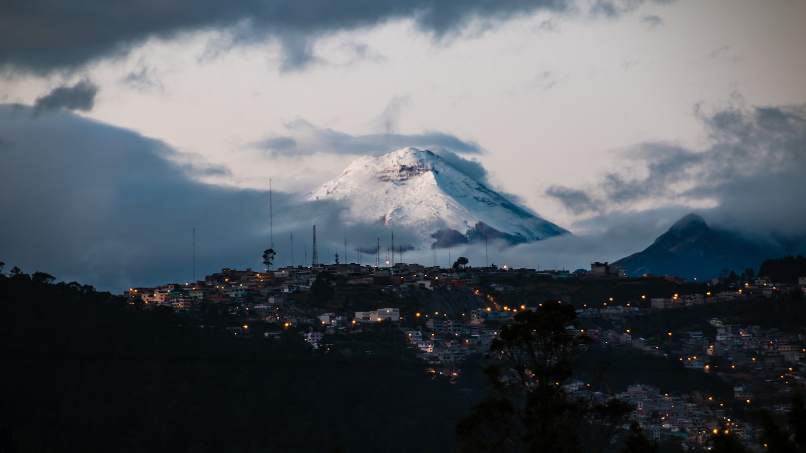 El volcán Cotopaxi sobre las luces de Quito al anochecer